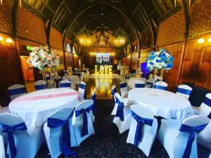 wedding venue tables dressed with artificial flowers in soft pinks and blues