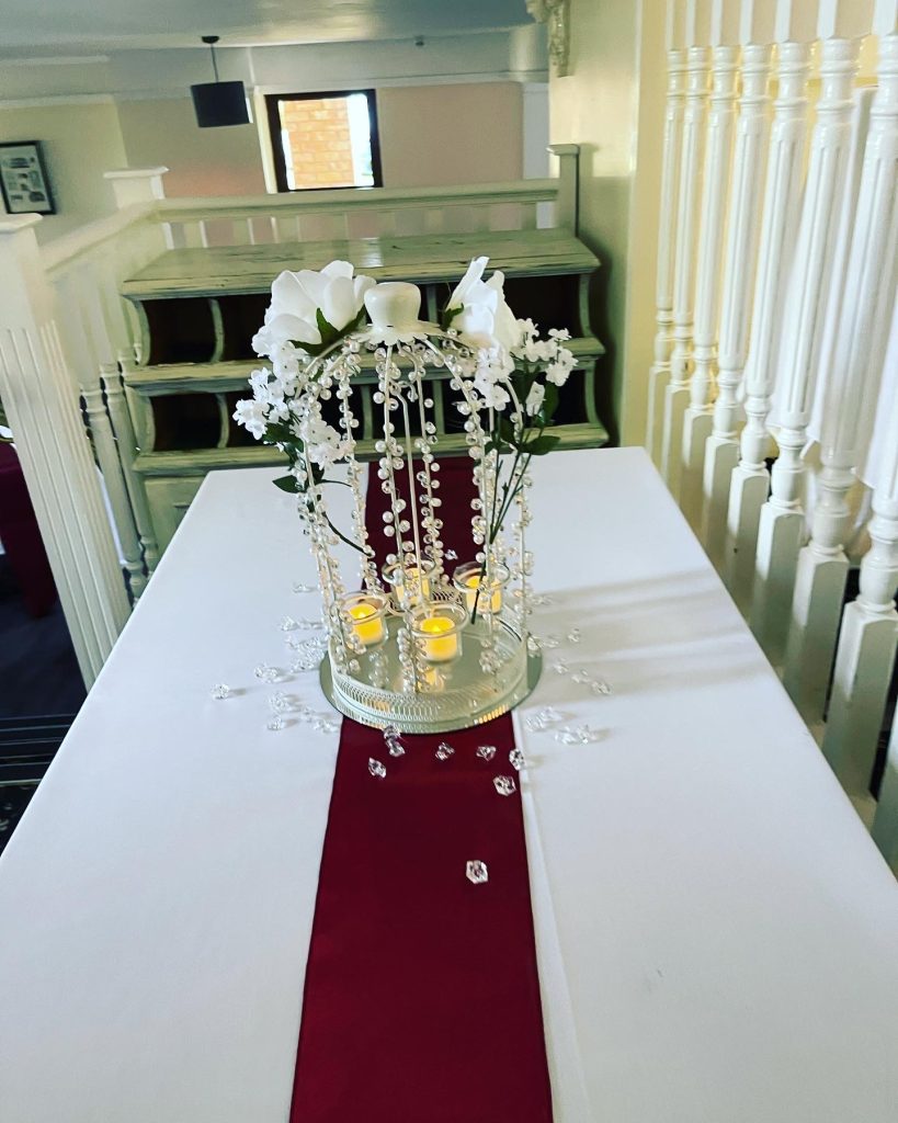 pretty votive candle centrepiece with artificial flowers and faux-diamonds for wedding