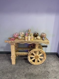 wooden candy cart stocked with variety of sweets for wedding or party
